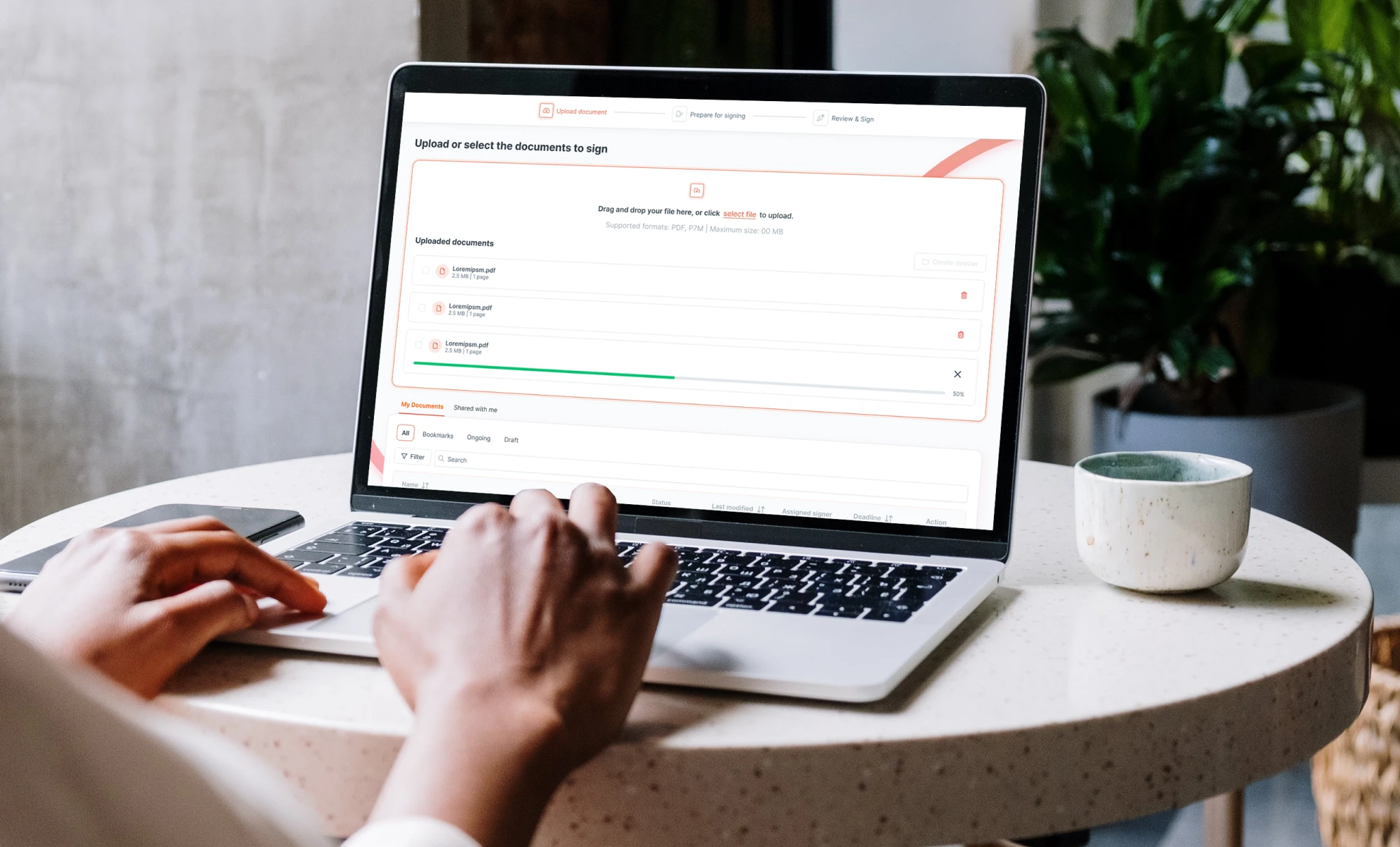 Persona che utilizza la piattaforma di firma elettronica wSign su un laptop, caricando documenti PDF per la firma digitale in un ambiente di lavoro moderno.