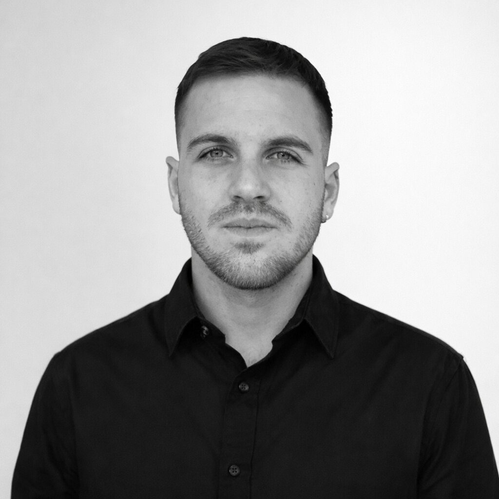 Ritratto professionale in bianco e nero di un business developer con camicia scura.